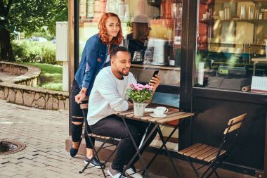 İçme kahve, kahve dükkan yakın oturan çift. Açık havada bir tarihte.