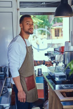 Afrikalı-Amerikalı barista kahve dükkanında profesyonel kahve makinesi ile bir kahve yapma.