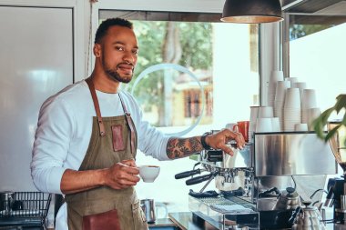 Afrikalı-Amerikalı barista kahve dükkanında profesyonel kahve makinesi ile bir kahve yapma.