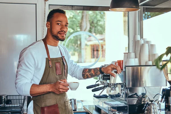 Afrikalı-Amerikalı barista kahve dükkanında profesyonel kahve makinesi ile bir kahve yapma.
