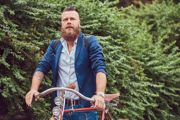 Мужчина одет в повседневную одежду, стоит с ретро-велосипедом в парке . — стоковое фото