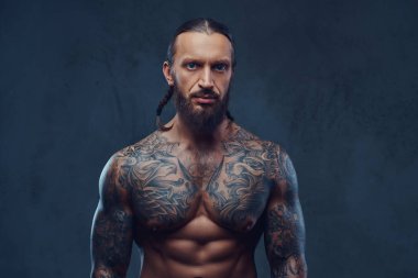 Şık bir saç kesimi, karanlık bir arka plan üzerinde izole kas sakallı tattoed erkekle yakın çekim portresi.