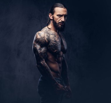 Şık bir saç kesimi, karanlık bir arka plan üzerinde izole kas çıplak sakallı tattoed erkekle yakın çekim portresi.