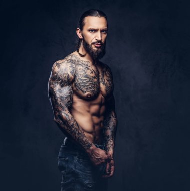 Şık bir saç kesimi, karanlık bir arka plan üzerinde izole kas çıplak sakallı tattoed erkekle yakın çekim portresi.