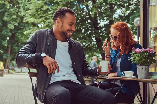 Um casal a beber café, sentado perto do café. Ao ar livre em uma data . — Fotografia de Stock