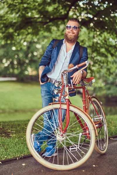Мандрівник одягнений в повсякденний одяг і сонцезахисні окуляри з рюкзаком, розслабляється в міському парку після їзди на ретро велосипеді . — стокове фото