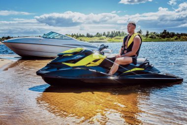 Jet ski, bir sahil üzerinde sürme mutlu yakışıklı sporcu.
