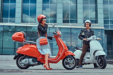Çekici Romantik Çift, yakışıklı ve seksi erkek bir gökdelen karşı retro İtalyan scooter üzerinde oturuyor. Telefonla konuşurken kız süre bekleyen bir adam.