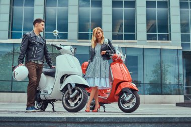 Bir çekici Romantik Çift, yakışıklı ve seksi kadın zaman harcamak birlikte açık havada bir gökdelen karşı. Scooter ile bir tarih yürüyüş.