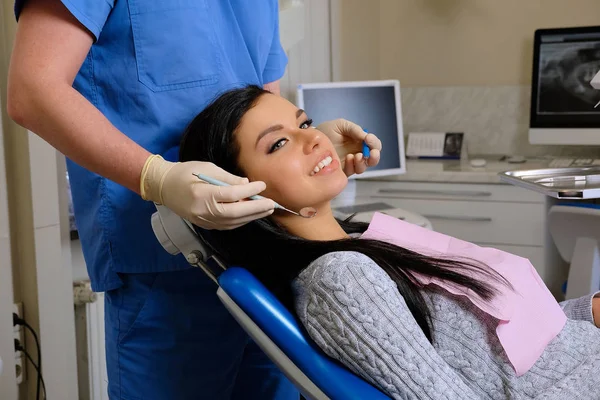 Dentista curando a una paciente femenina en un consultorio dental. Odontología cuidado mujer visita —  Fotos de Stock