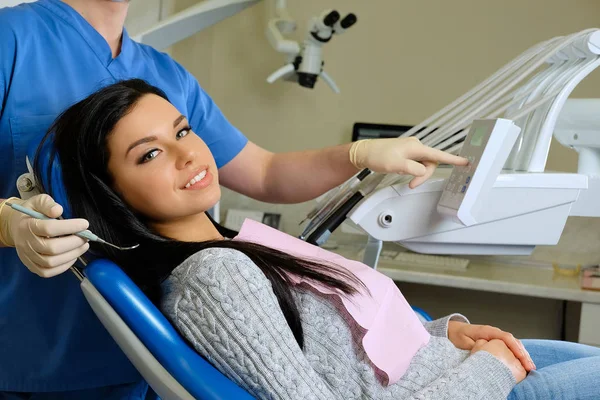 Bir diş hekimi diş araçları olan genç kadın hasta üzerinde eller. — Stok fotoğraf