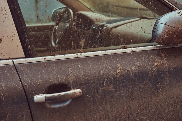 Close-up image of a dirty car after a trip around the countryside. Side view