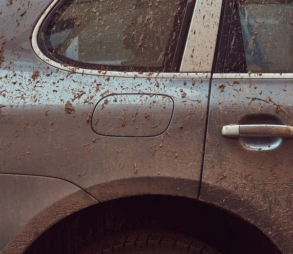Close-up image of a dirty car after a trip around the countryside. Side view