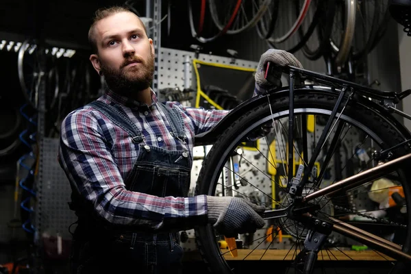 Bir Bisiklet Tekerleği Bir Tamir Dükkanında Çalışan Bir Fanila Coverall — Stok fotoğraf