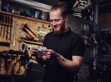 Bir yakışıklı gülümseyen Kızıl işçi, kirli elleri bir atölyede çalışan onarımından sonra Temizleme. 