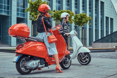 Çekici bir romantik çift, yakışıklı ve seksi erkek bir gökdelen karşı retro İtalyan scooter üzerinde oturuyor. Telefonla konuşurken kız süre bekleyen bir adam.