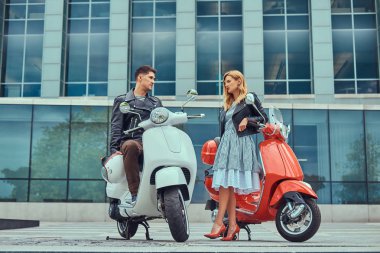 Çekici Romantik Çift, yakışıklı ve seksi erkek birlikte açık havada bir gökdelen karşı vakit. Scooter ile bir tarih yürüyüş.