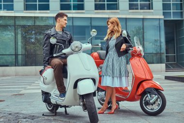 Çekici Romantik Çift, yakışıklı ve seksi erkek birlikte açık havada bir gökdelen karşı vakit. Scooter ile bir tarih yürüyüş.