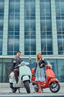 Çekici Romantik Çift, yakışıklı ve seksi erkek birlikte açık havada bir gökdelen karşı vakit. Scooter ile bir tarih yürüyüş.