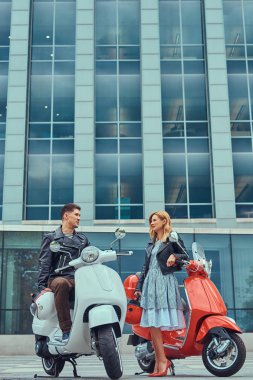Çekici Romantik Çift, yakışıklı ve seksi erkek birlikte açık havada bir gökdelen karşı vakit. Scooter ile bir tarih yürüyüş.