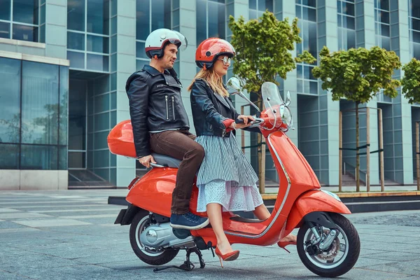 迷人的情侣 一个英俊的男人和性感的女子一起骑在一个红色的复古摩托车在一个城市 — 图库照片