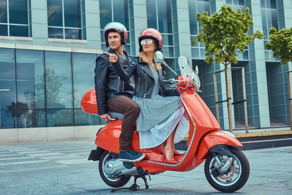 一个迷人的夫妇 一个英俊的男人和性感的女人一起骑在一个红色的复古摩托车在一个城市 — 图库照片
