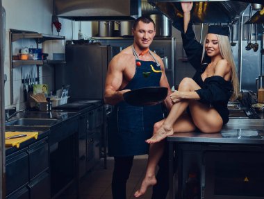 Kadın iç çamaşırı seksi garson masaya oturur, çekici bir aşçı ile flört ediyor.