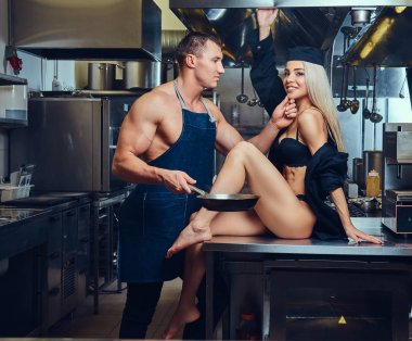 Kaslı bir Şef ile flört bir seksi sarışın garson, masanın üzerinde çamaşırlarıyla.