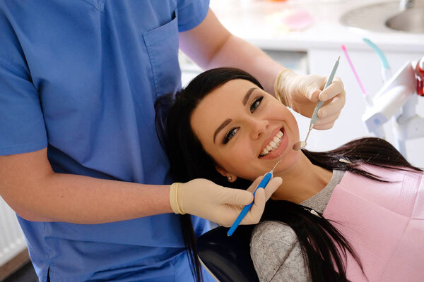 A beauty brunette having teeth examined at dentists.