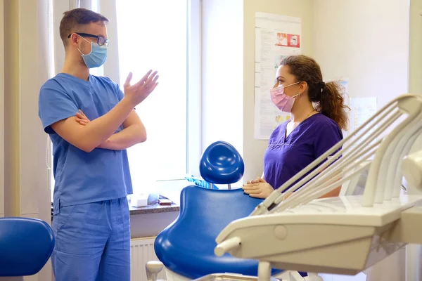 Bonito Dentista Masculino Fala Com Uma Assistente Feminina Uma Clínica — Fotografia de Stock