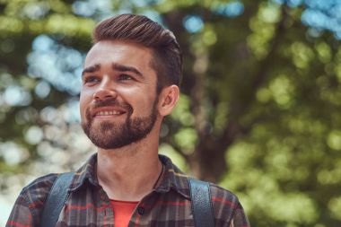 Şehir parkında duran bir Polar gömlek gülümseyen genç güzel bir öğrenci ile şık saç ve sakal, yakın çekim portresi.