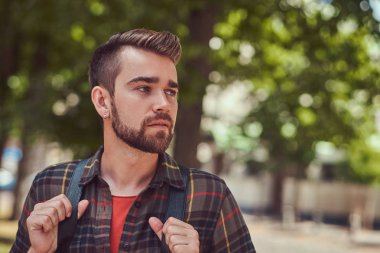 Şehir parkında duran bir Polar gömlek giymiş genç güzel bir öğrenci ile şık saç ve sakal, yakın çekim portresi.