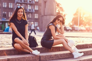 İki kadın turist, dinlendirici bir yürüyüş manzaraları, sonra parlak günbatımı çerçevede bir taş basamaklar üzerinde oturan bir harita bakın.