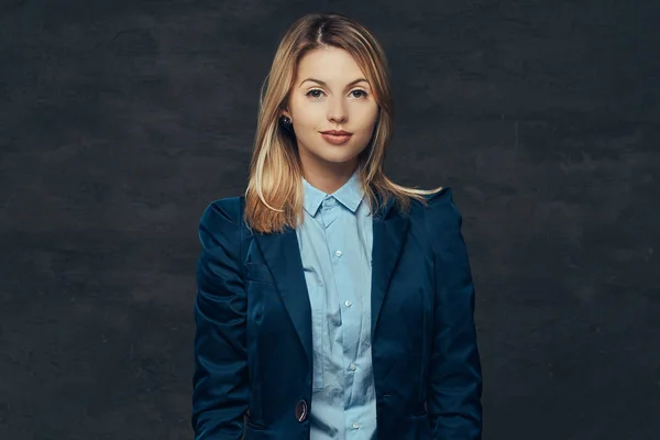 Portrait of a sensual blonde business woman dressed in a formal suit and blue shirt, posing in a studio. Isolated on a dark background. — Stock Photo, Image