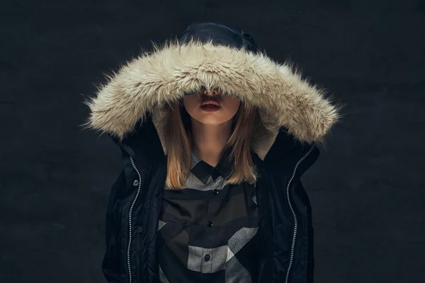 Portret van een sexy blonde meisje in een winter jas en fleece shirt, permanent in een studio. — Stockfoto