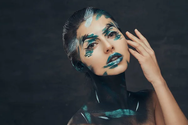 Μια αισθησιακή νεαρή κοπέλα με δημιουργικό μακιγιάζ. Μπλε και μαύρο σκιές ζωγραφισμένη στο πρόσωπό της. Εννοιολογική ιδέα. — Φωτογραφία Αρχείου