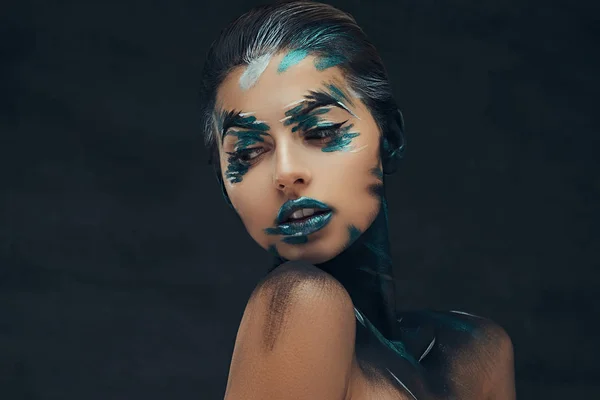 Een sensuele meisje met creatieve make-up. Blauwe en zwarte schaduwen geschilderd op haar gezicht. Conceptueel idee. — Stockfoto