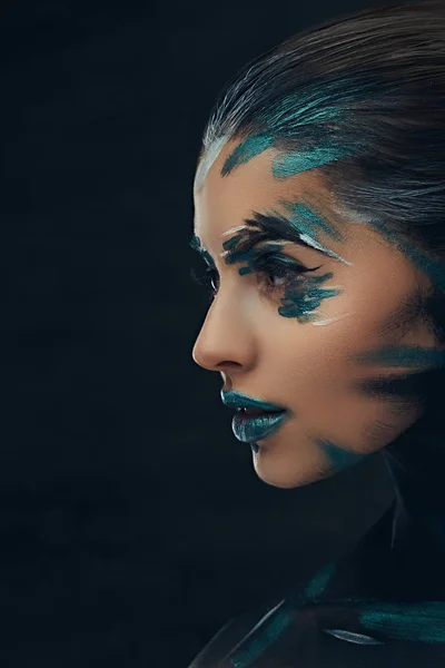 Een sensuele meisje met creatieve make-up. Blauwe en zwarte schaduwen geschilderd op haar gezicht. Conceptueel idee. — Stockfoto