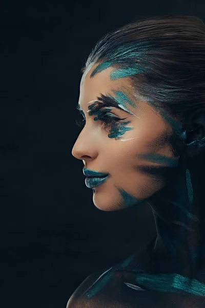 Een sensuele meisje met creatieve make-up. Blauwe en zwarte schaduwen geschilderd op haar gezicht. Conceptueel idee. — Stockfoto