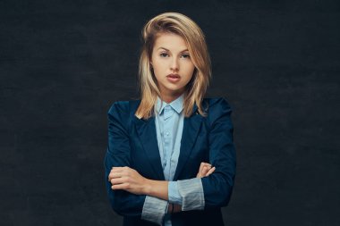 Bir stüdyoda poz bir resmi elbise ve mavi gömlek giymiş bir şehvetli sarışın iş kadın portresi. Karanlık bir arka plan üzerinde izole.