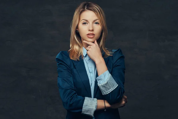 Retrato de uma mulher de negócios loira sensual vestida com um terno formal e camisa azul, posando em um estúdio. Isolado em um fundo escuro . — Fotografia de Stock