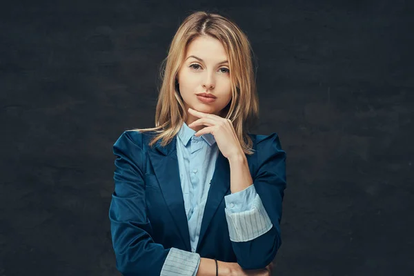 Retrato de una sensual mujer de negocios rubia vestida con un traje formal y una camisa azul, posando en un estudio. Aislado sobre un fondo oscuro . — Foto de Stock