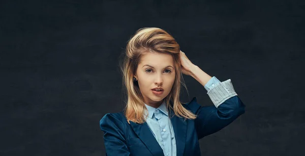 Porträt einer sinnlichen blonden Geschäftsfrau im formellen Anzug und blauem Hemd, die in einem Studio posiert. isoliert auf dunklem Hintergrund. — Stockfoto