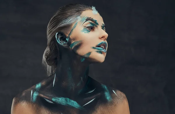 En ung sensuell flicka med creative make-up. Blå och svarta skuggor målade på hennes ansikte. Konceptuell idé. — Stockfoto