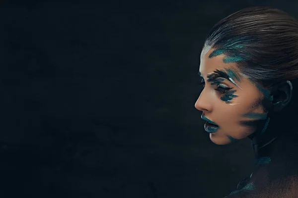 Een sensuele meisje met creatieve make-up. Blauwe en zwarte schaduwen geschilderd op haar gezicht. Conceptueel idee. — Stockfoto