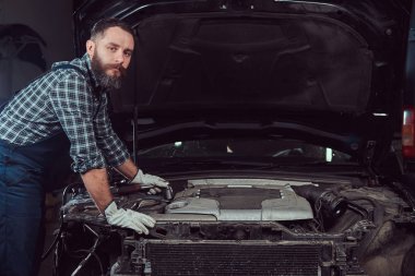 Garajda araba tamir üniformalı mekanik adam. Servis istasyonu.