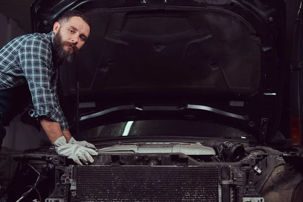 Garajda araba tamir üniformalı mekanik adam. Servis istasyonu.