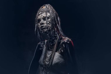 Yakın çekim bir cadıdan geleneksel kostüm giyen Yerli Afrikalı kabile portresi. Kalıcı makyaj kavramı. Karanlık bir arka plan üzerinde izole.