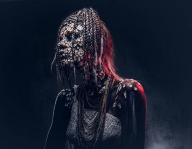 Yakın çekim bir cadıdan geleneksel kostüm giyen Yerli Afrikalı kabile portresi. Kalıcı makyaj kavramı. Karanlık bir arka plan üzerinde izole.