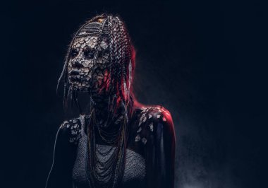 Yakın çekim bir cadıdan geleneksel kostüm giyen Yerli Afrikalı kabile portresi. Kalıcı makyaj kavramı. Karanlık bir arka plan üzerinde izole.